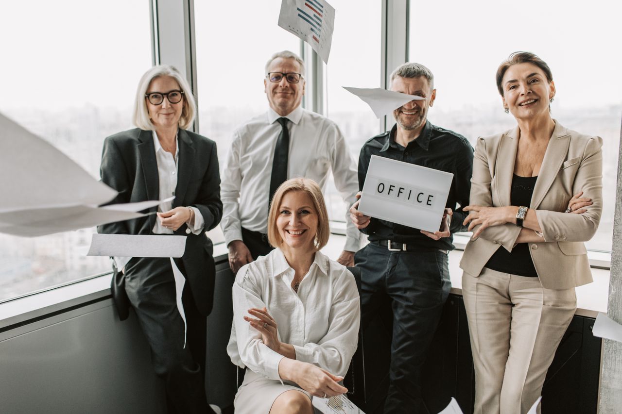 Group of business professionals celebrating achievements inside a modern office space.
